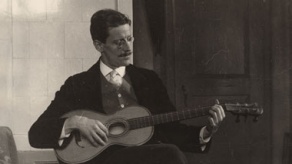 Photo of James Joyce playing guitar. 