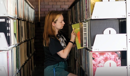 Student browses the Music Library's collection of vinyls.