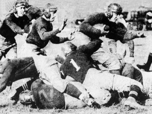 Captain Jim Ailinger plows through the Thiel College ranks. 