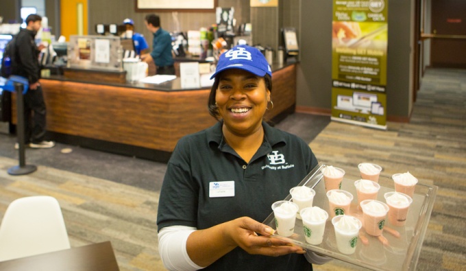 Barista holds a tray of samples at Whispers Cafe in Abbott Library. 