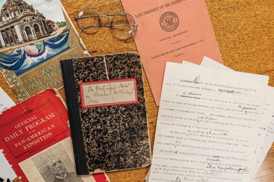 Flat lay of assassination documents and a pair of glasses. 