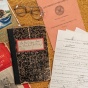 Flat lay of assination documents and a pair of glasses. 