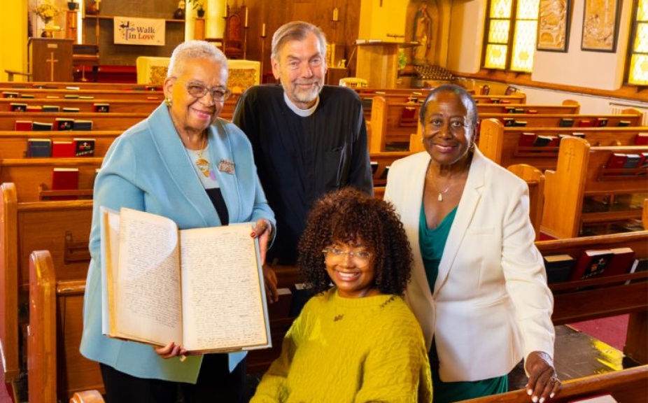 Four people holding up a record in St. Philip’s Episcopal Church. 
