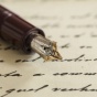 Fountain pen on a paper with cursive writing. 