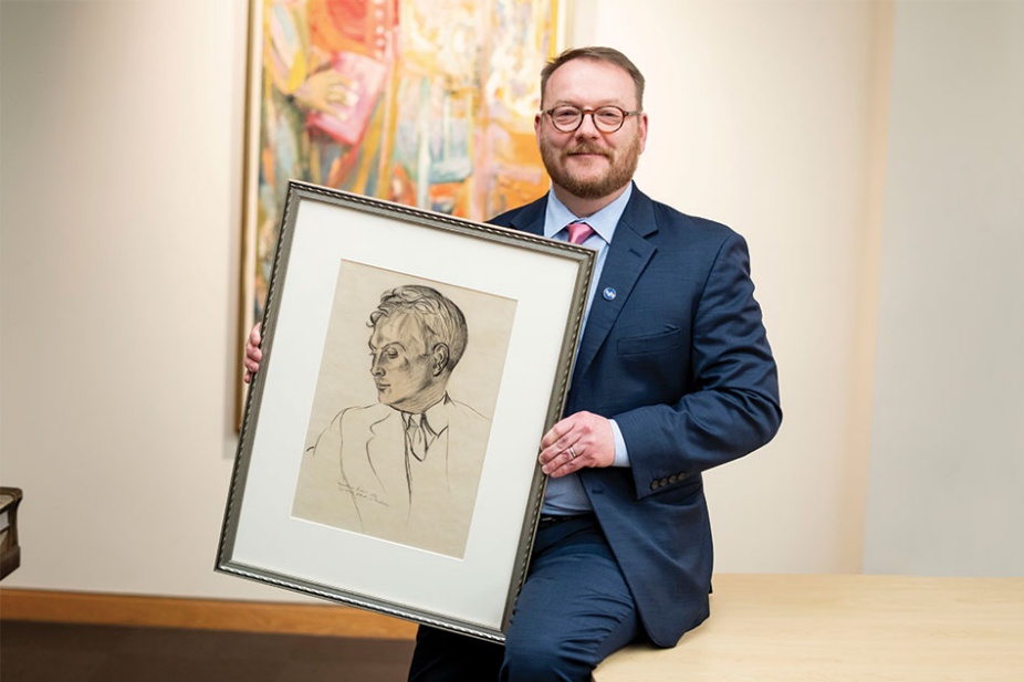 James Maynard holds a 1939 drawing of Charles Abbott by artist and writer Wyndham Lewis in Special Collections.