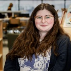 UB Libraries student assistant Corina Carr, shown in Lockwood Memorial Library, earned a master’s degree in information and library science in May 2025. 