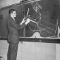 Black and white old photo of a UB student using a chalkboard for his studies. 