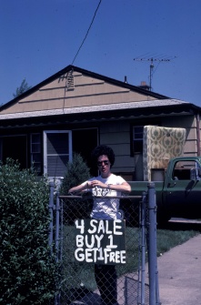 10002 Colvin Boulevard resident Marie Posniak evacuating her home with a sign: '4 Sale Buy 1, Get 1 Free' in the Love Canal neighborhood, Niagara Falls, New York, July 3, 1980. 