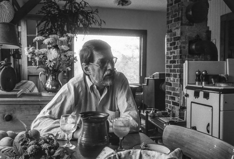 Robert Creeley sitting in the kitchen.